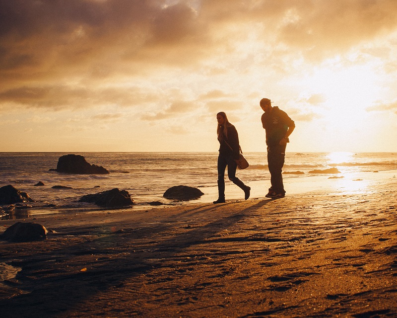 couple walking on sandy beach