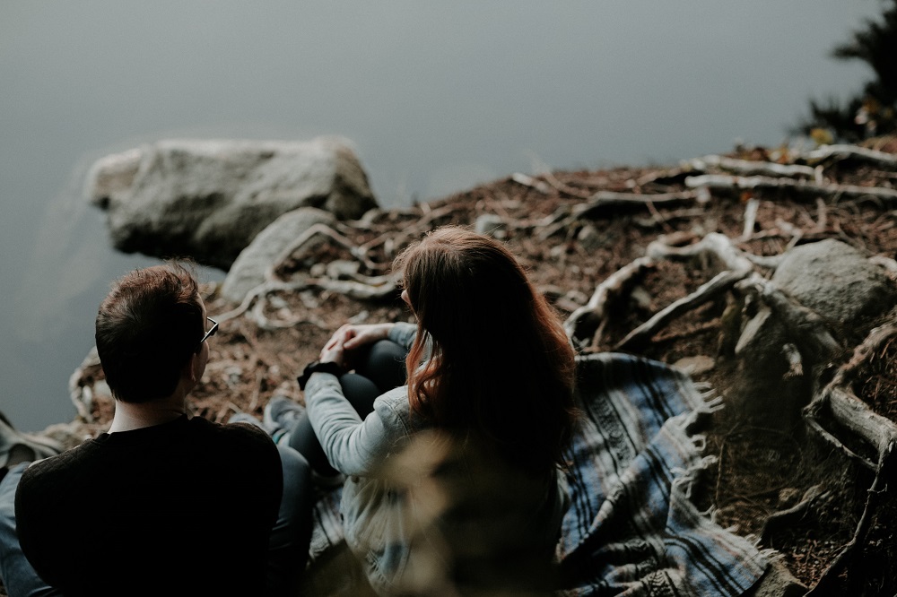 couple talking by rocky shore